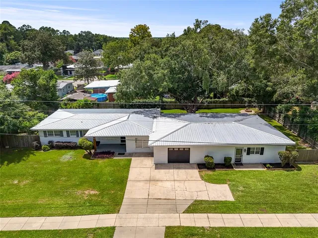 a aerial view of a house with swimming pool and a yard