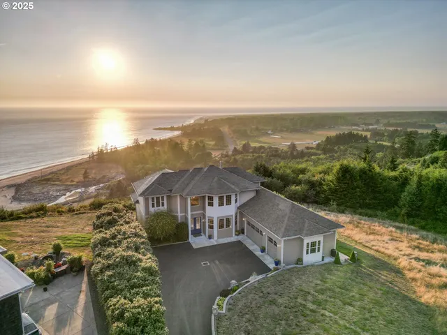 an aerial view of residential houses with outdoor space and ocean view