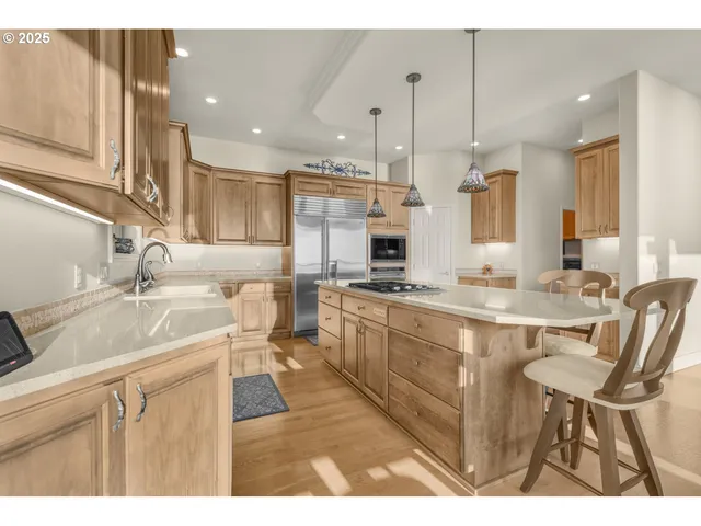 a large kitchen with kitchen island a sink table and chairs