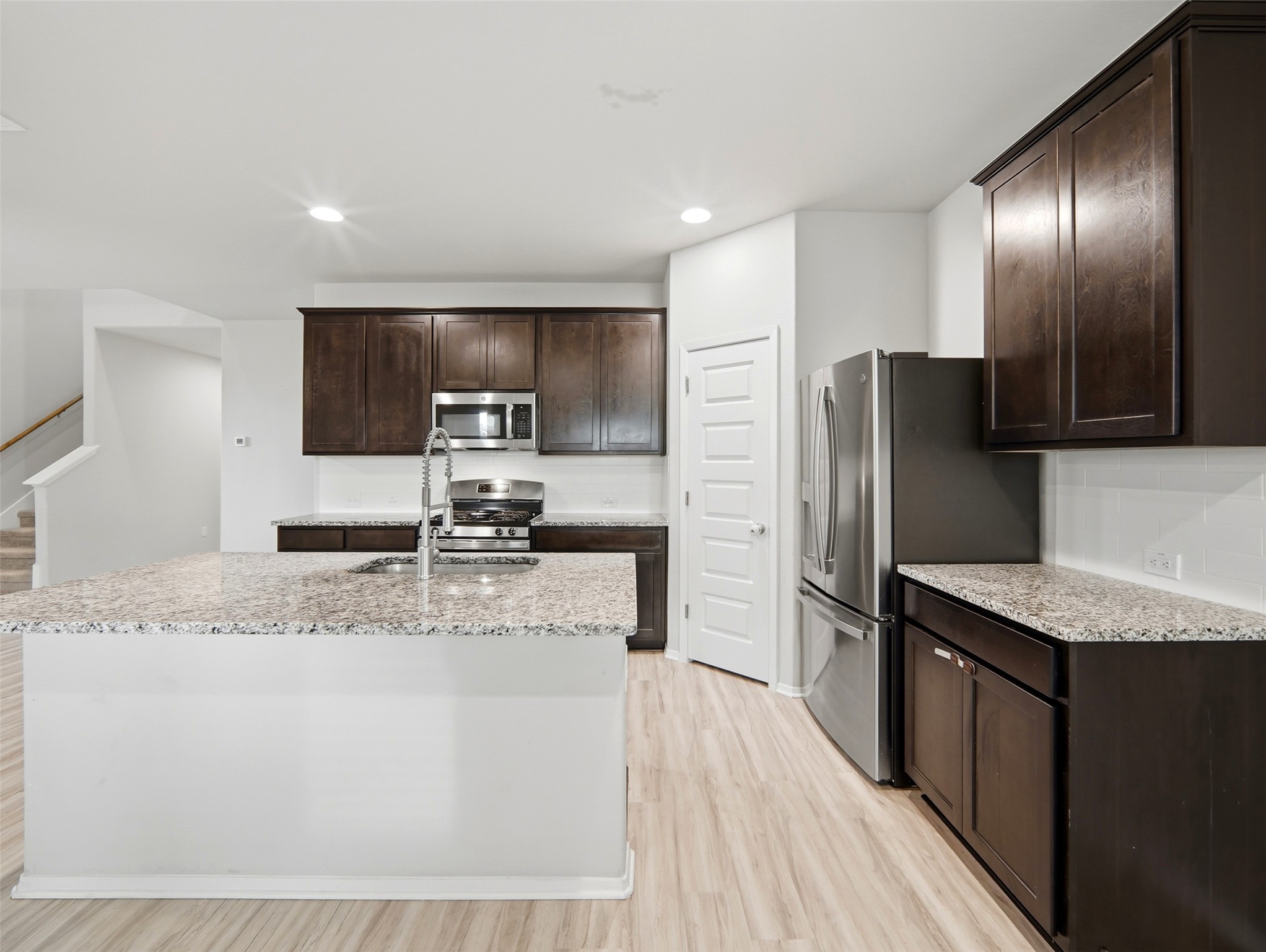 60 Bent Trl Lane Georgetown, TX 78628 - Photo 9 of 40 A well-appointed kitchen features rich cabinetry, granite countertops, and modern stainless steel appliances.