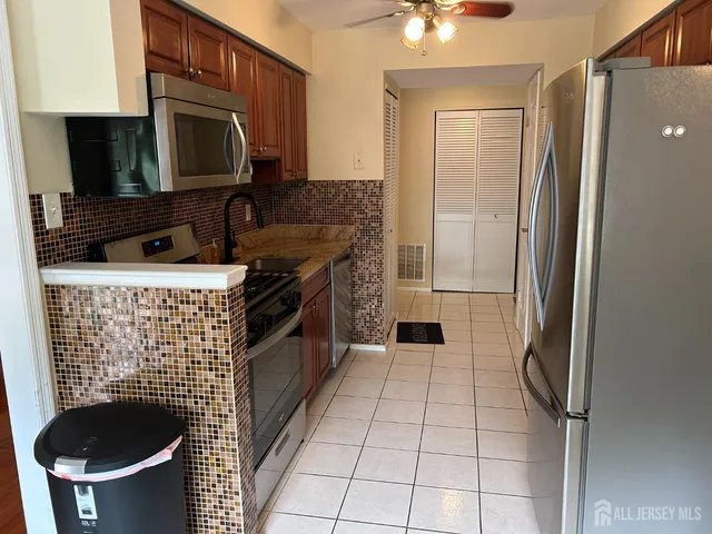 a kitchen with granite countertop a refrigerator a stove a microwave and island