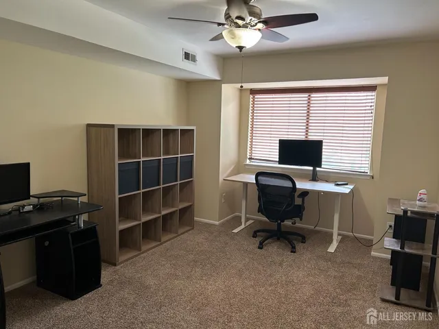 a view of a workspace with furniture and a window