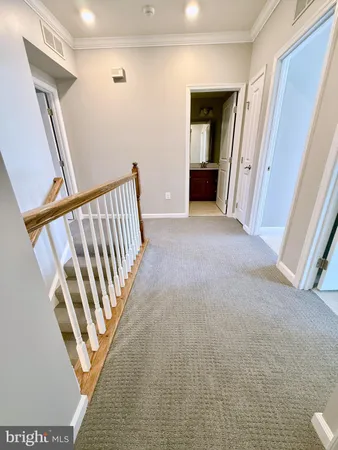 a view of a hallway with wooden floor and stairs