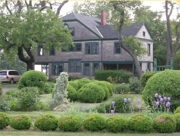 a front view of a house with a yard and outdoor seating