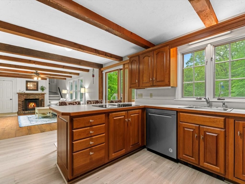 157 Harvard Road Bolton, MA 01740 - Photo 13 of 42 a kitchen with granite countertop wooden cabinets a sink and dishwasher a stove with wooden floor