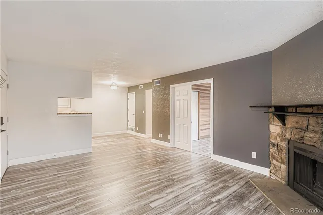 a view of empty room with wooden floor and fireplace