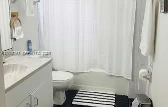 19900 Southwest 326th Street, Unit 1 Homestead, FL 33030 - Photo 7 of 11 a bathroom with a sink a toilet and shower curtain