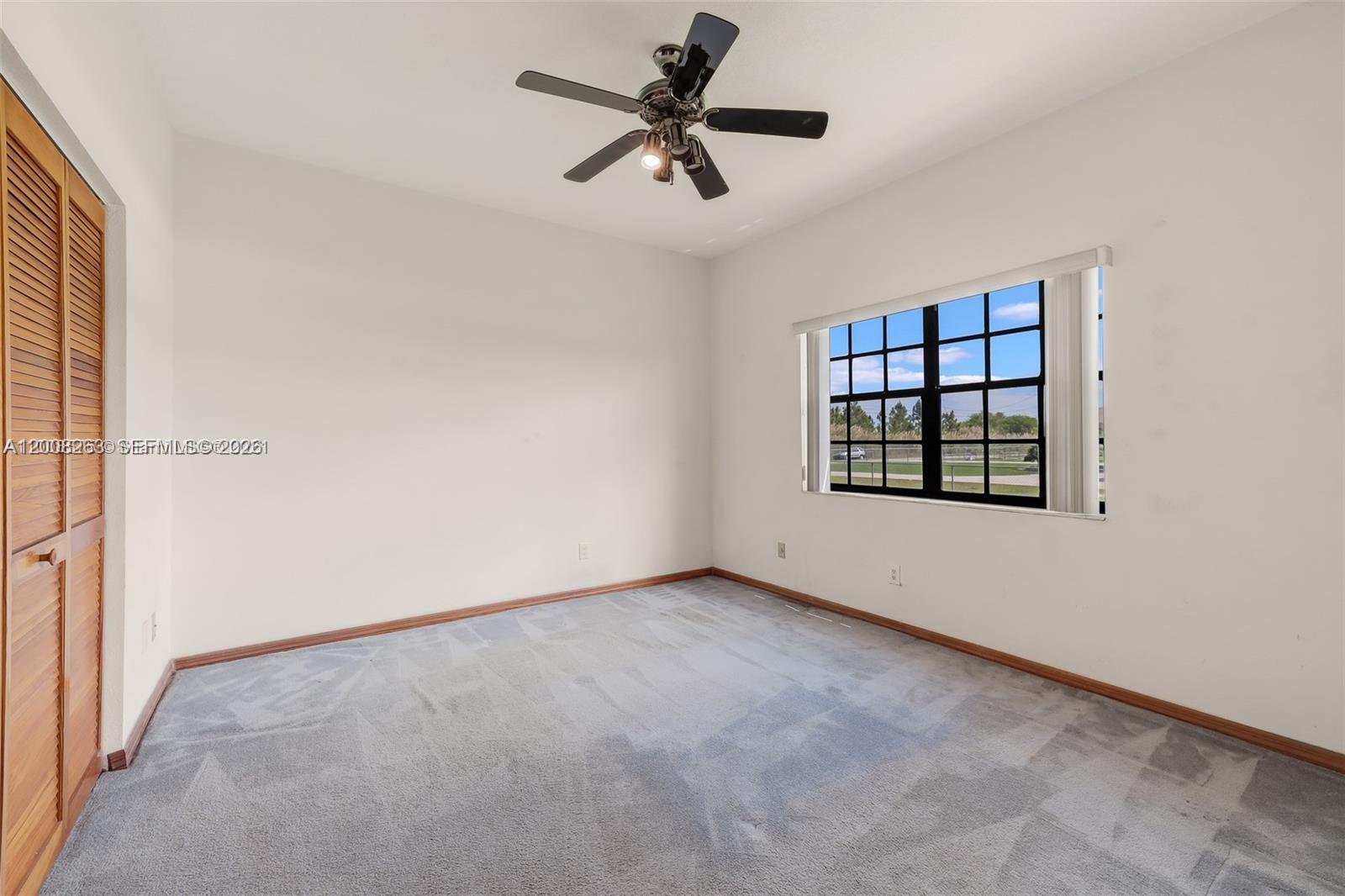19900 Southwest 326th Street, Unit 1 Homestead, FL 33030 - Photo 10 of 11 an empty room with windows and ceiling fan