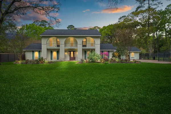 a front view of a house with a yard and trees