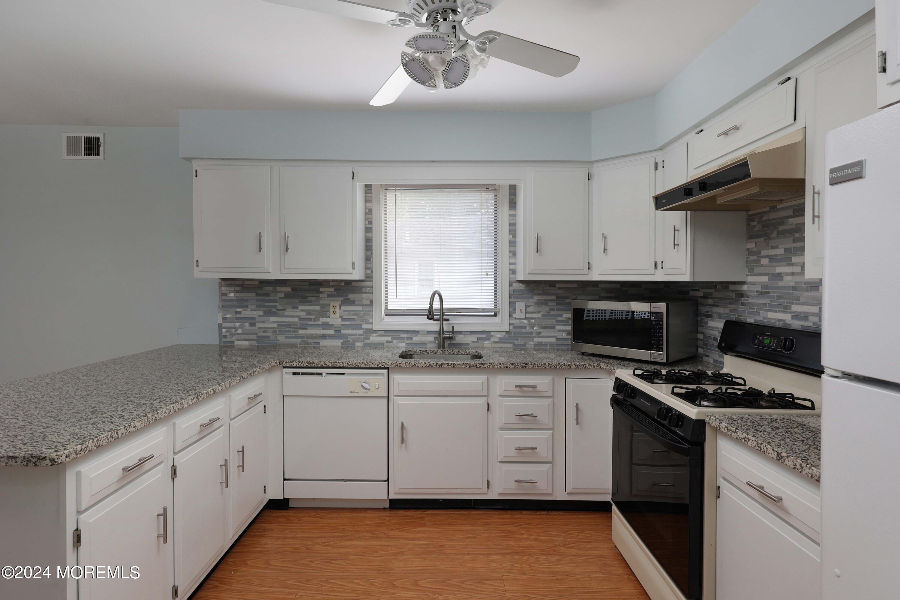 98 Greenbriar Boulevard Brick, NJ 08724 - Photo 13 of 31 a kitchen with stainless steel appliances kitchen island granite countertop a sink and cabinets