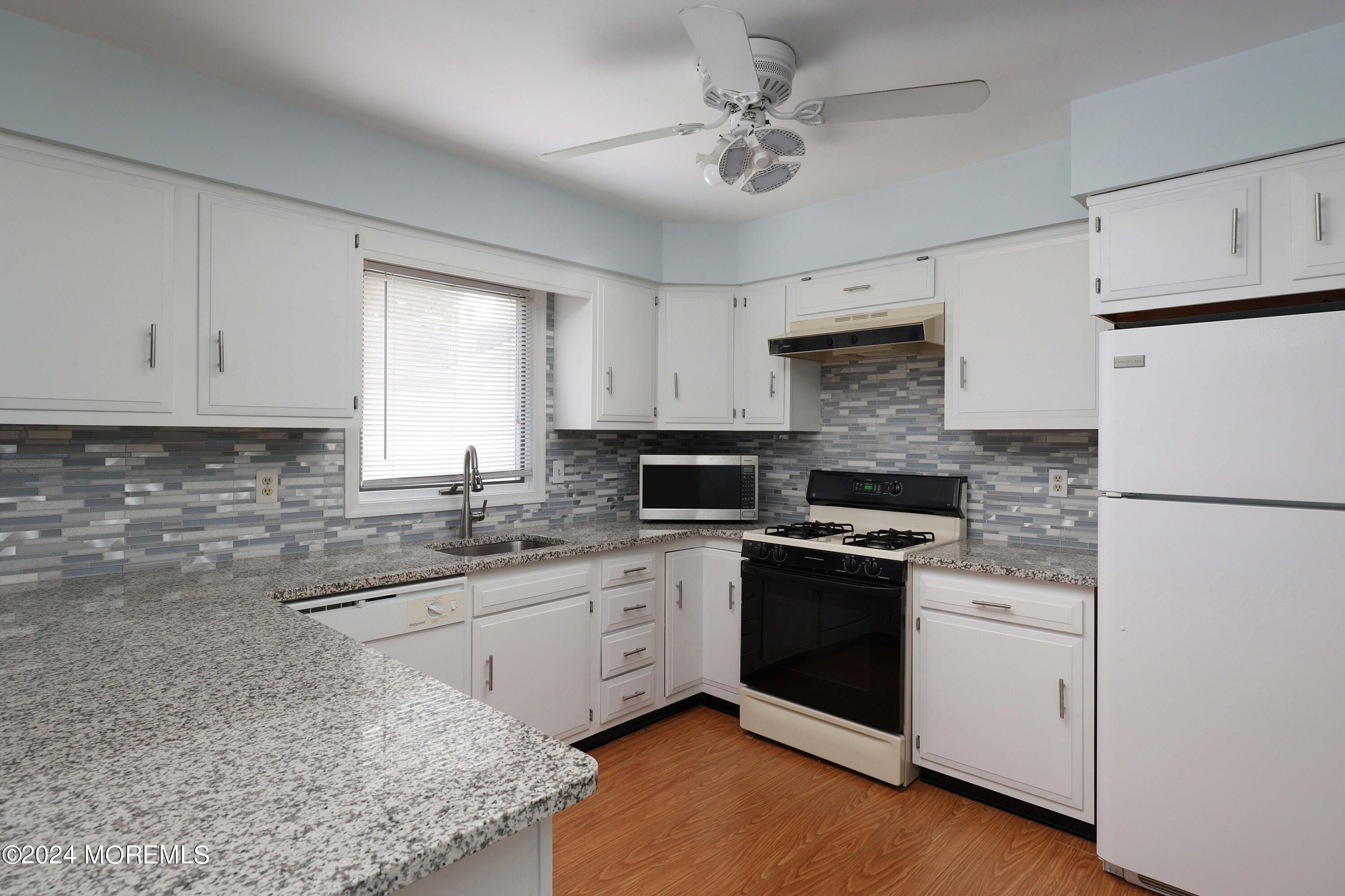 98 Greenbriar Boulevard Brick, NJ 08724 - Photo 14 of 31 a kitchen with stainless steel appliances granite countertop white cabinets a sink a stove a refrigerator and white cabinets