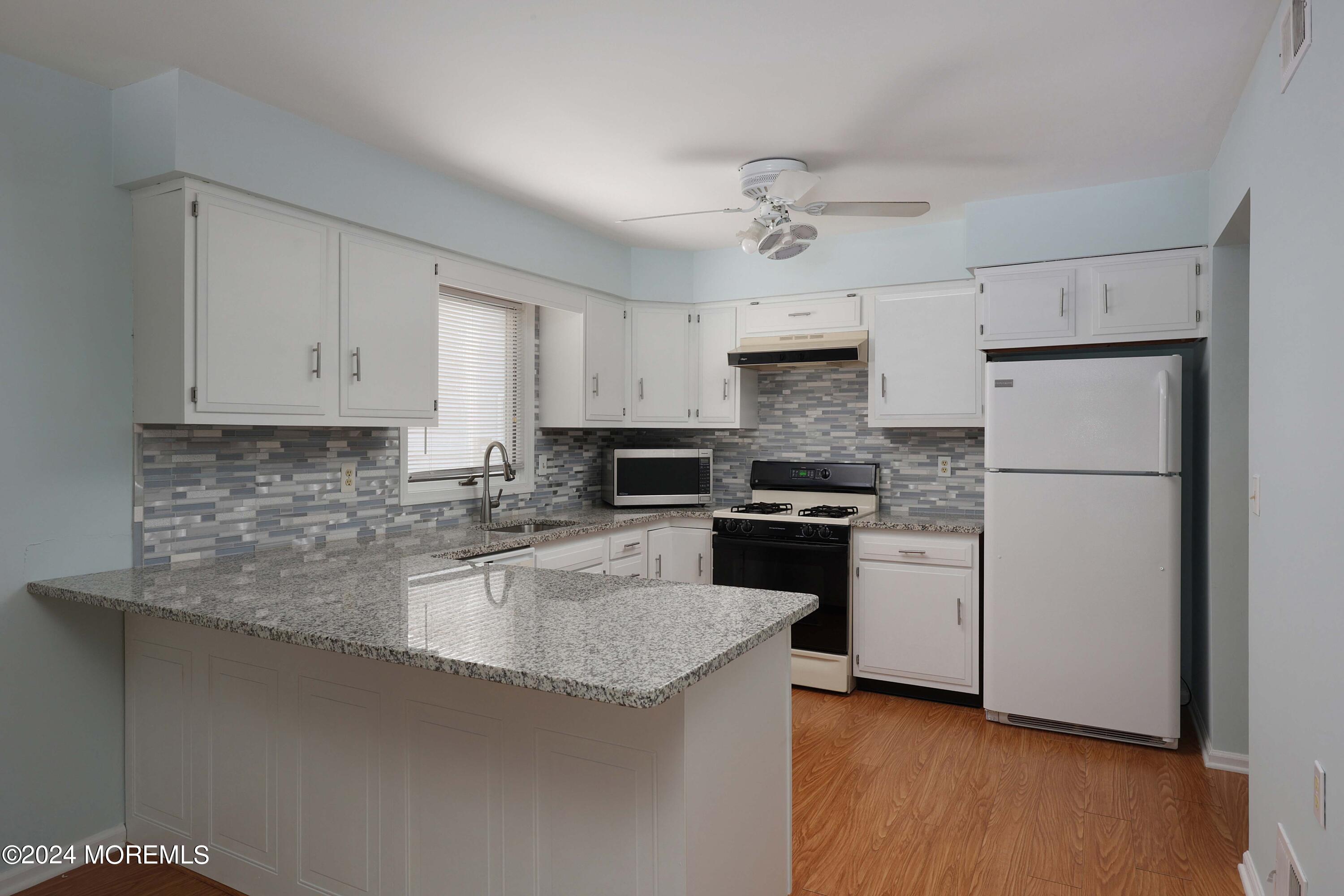 98 Greenbriar Boulevard Brick, NJ 08724 - Photo 15 of 31 a kitchen with granite countertop white cabinets and stainless steel appliances
