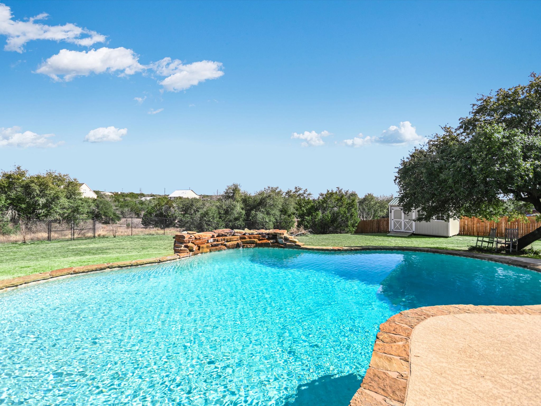 a view of a swimming pool and trees in the background