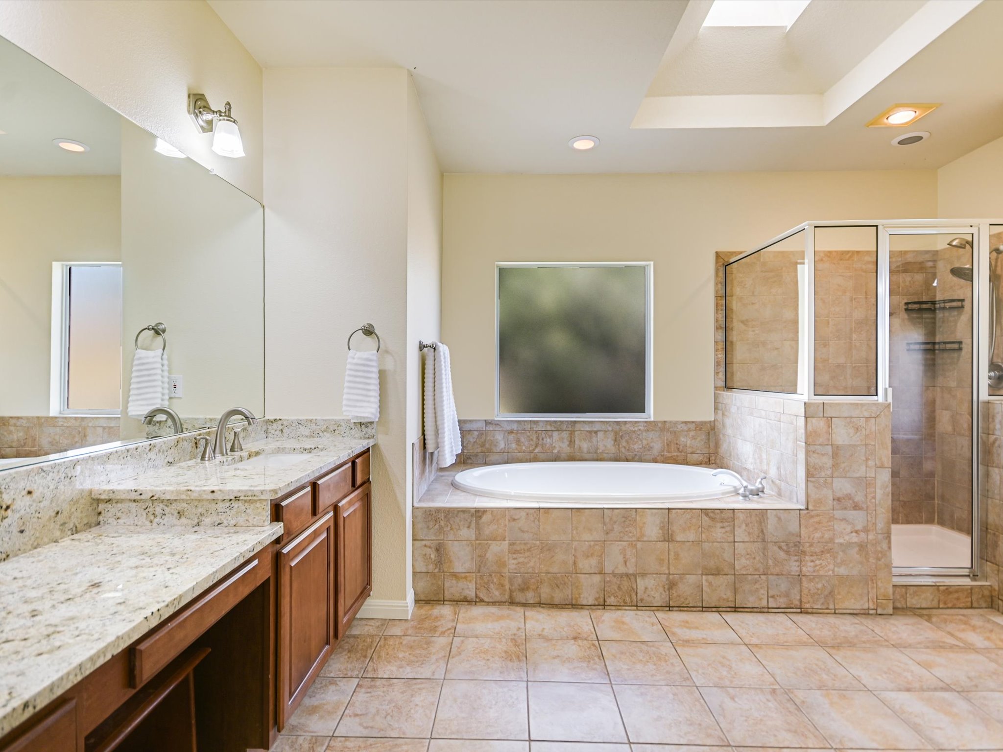 10111 Baxter Lane Austin, TX 78736 - Photo 18 of 35 a bathroom with a granite countertop sink a mirror and bathtub