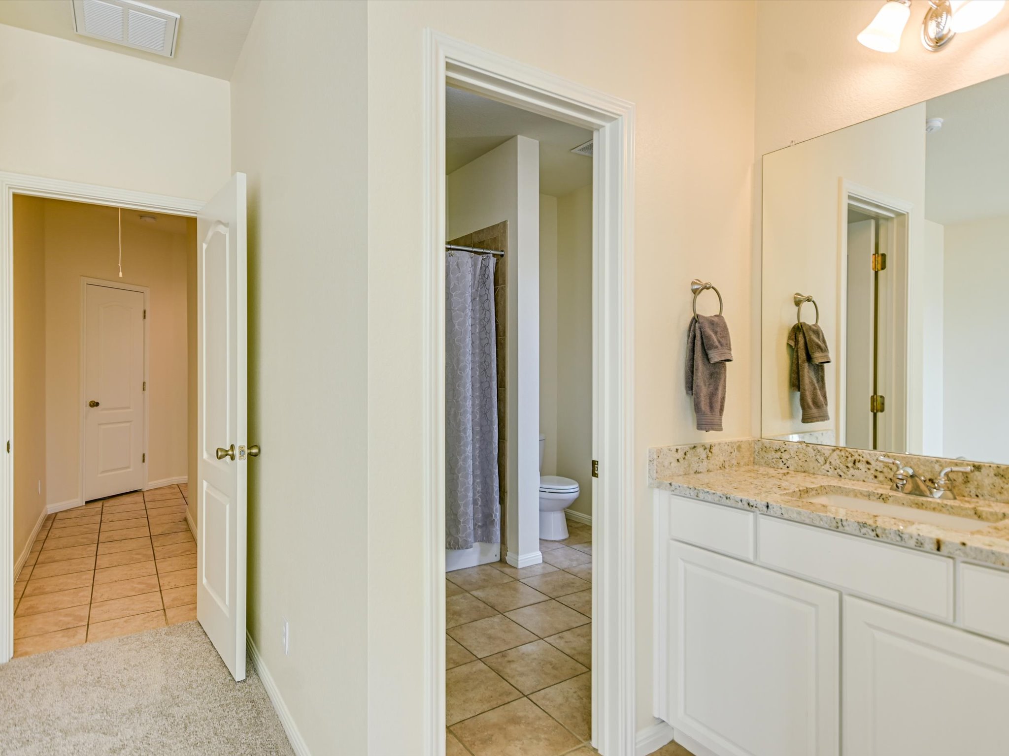 10111 Baxter Lane Austin, TX 78736 - Photo 25 of 35 a en suite bathroom with a granite countertop sink and a mirror