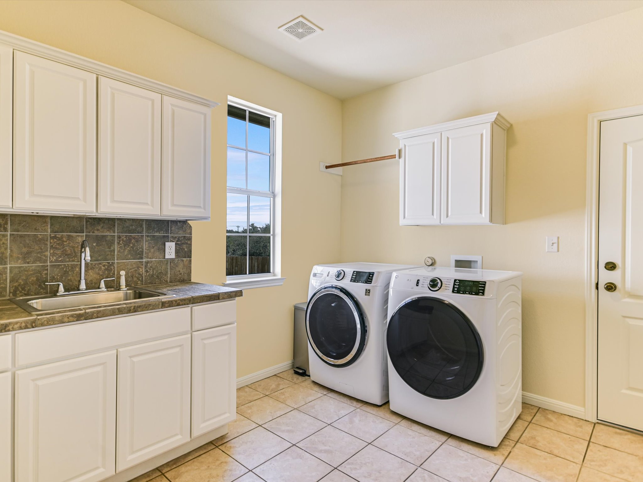 10111 Baxter Lane Austin, TX 78736 - Photo 26 of 35 a utility room with sink dryer and washer