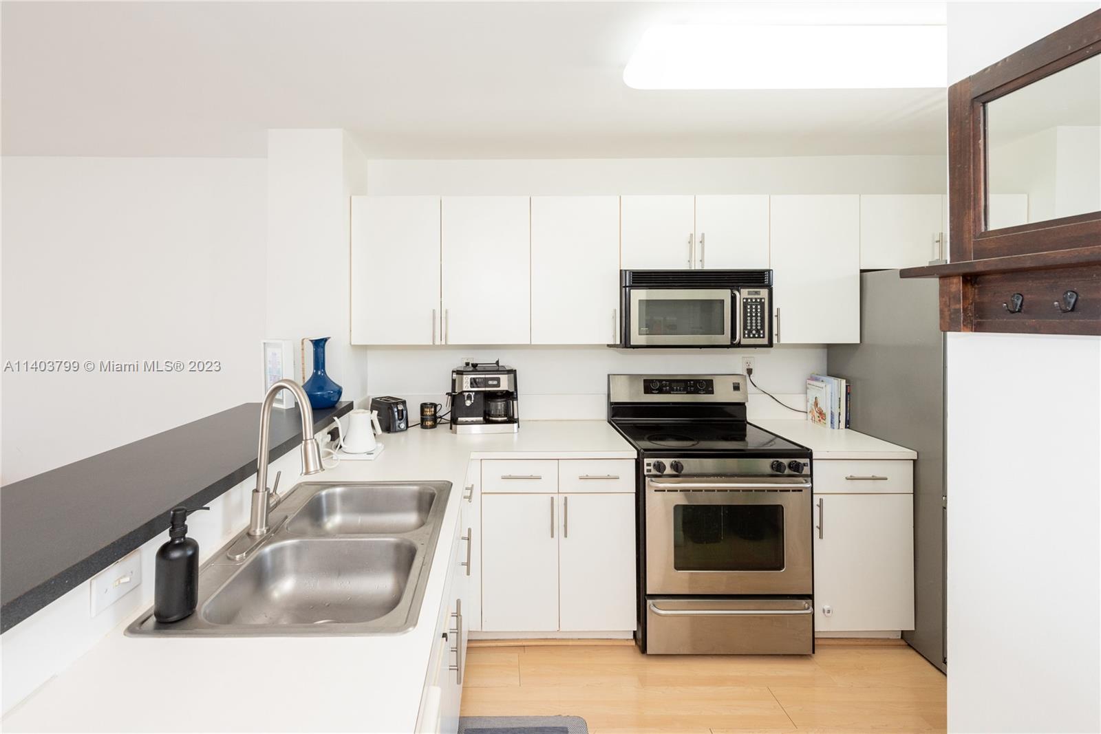 1401 Bay Road, Unit 503 Miami Beach, FL 33139 - Photo 9 of 18 a kitchen with a sink stove and microwave