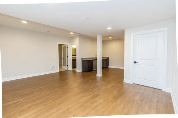 a view of a big room with wooden floor and windows