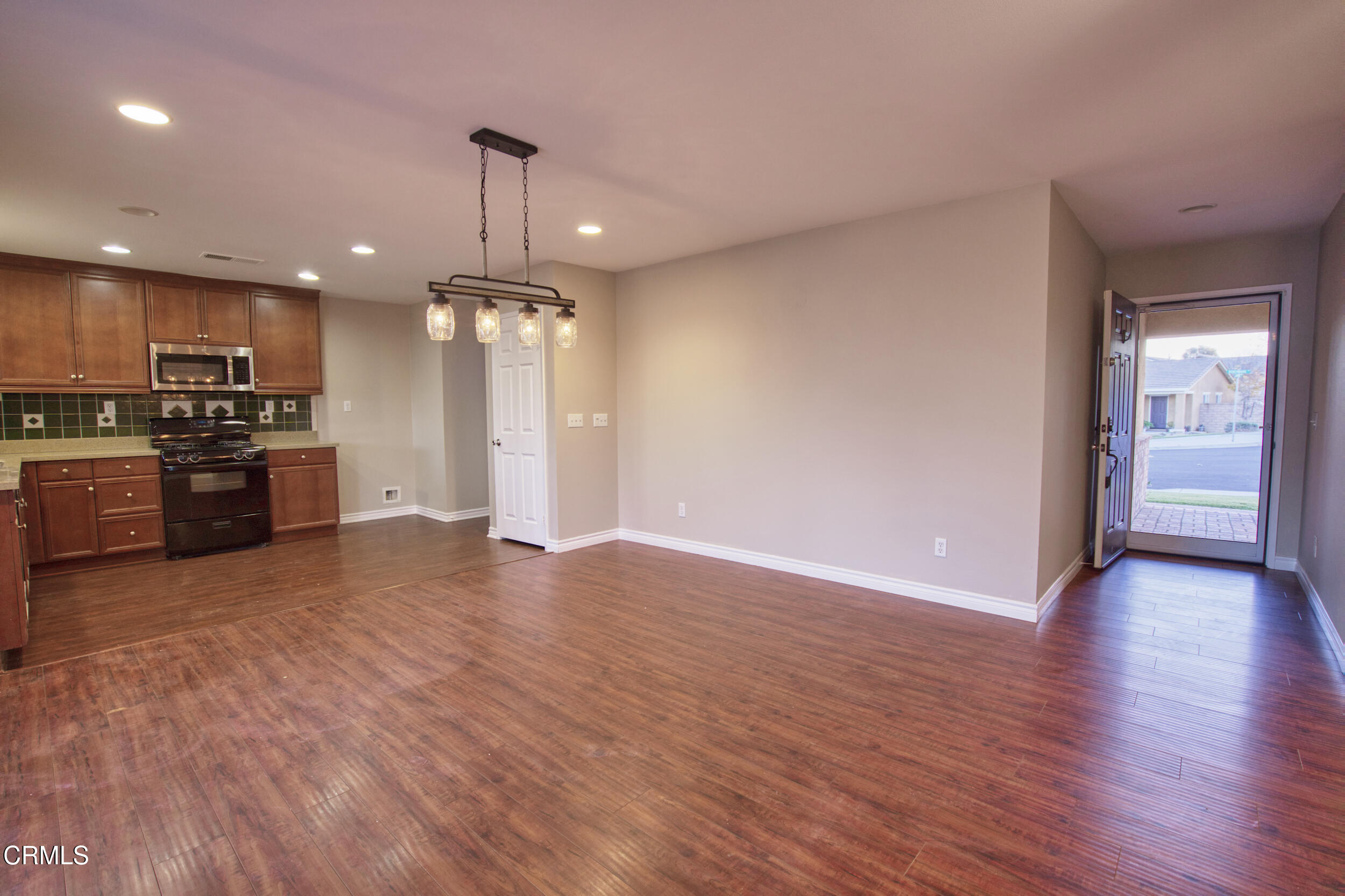 1350 Benchmark Street Beaumont, CA 92223 - Photo 7 of 25 a view of an empty room with kitchen stove and wooden floor
