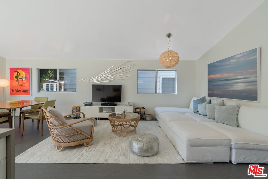 29 Paradise Cove Road Malibu, CA 90265 - Photo 2 of 30 a living room with furniture a flat screen tv and a chandelier
