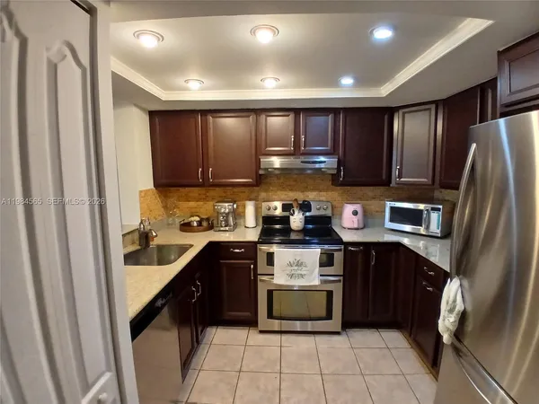 a kitchen with stainless steel appliances granite countertop a refrigerator and a stove top oven