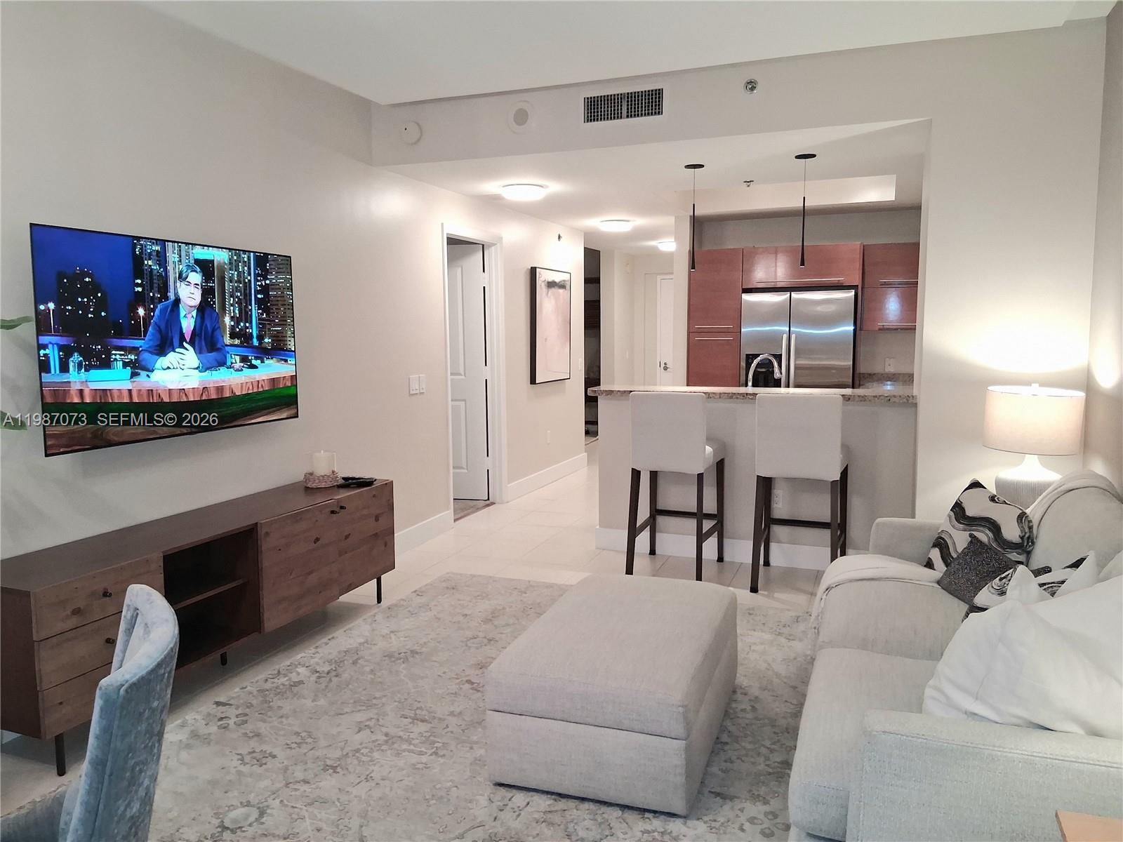 2641 North Flamingo Road, Unit 2607N Sunrise, FL 33323 - Photo 12 of 69 a living room with furniture and a flat screen tv