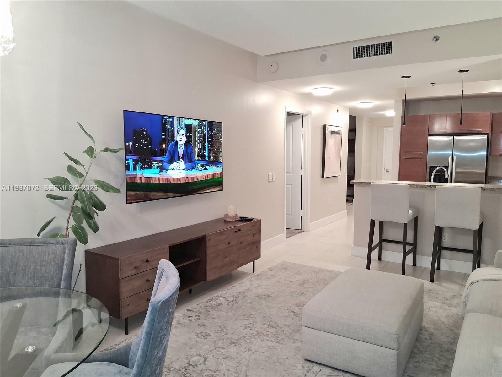 2641 North Flamingo Road, Unit 2607N Sunrise, FL 33323 - Photo 16 of 69 a living room with furniture and a flat screen tv