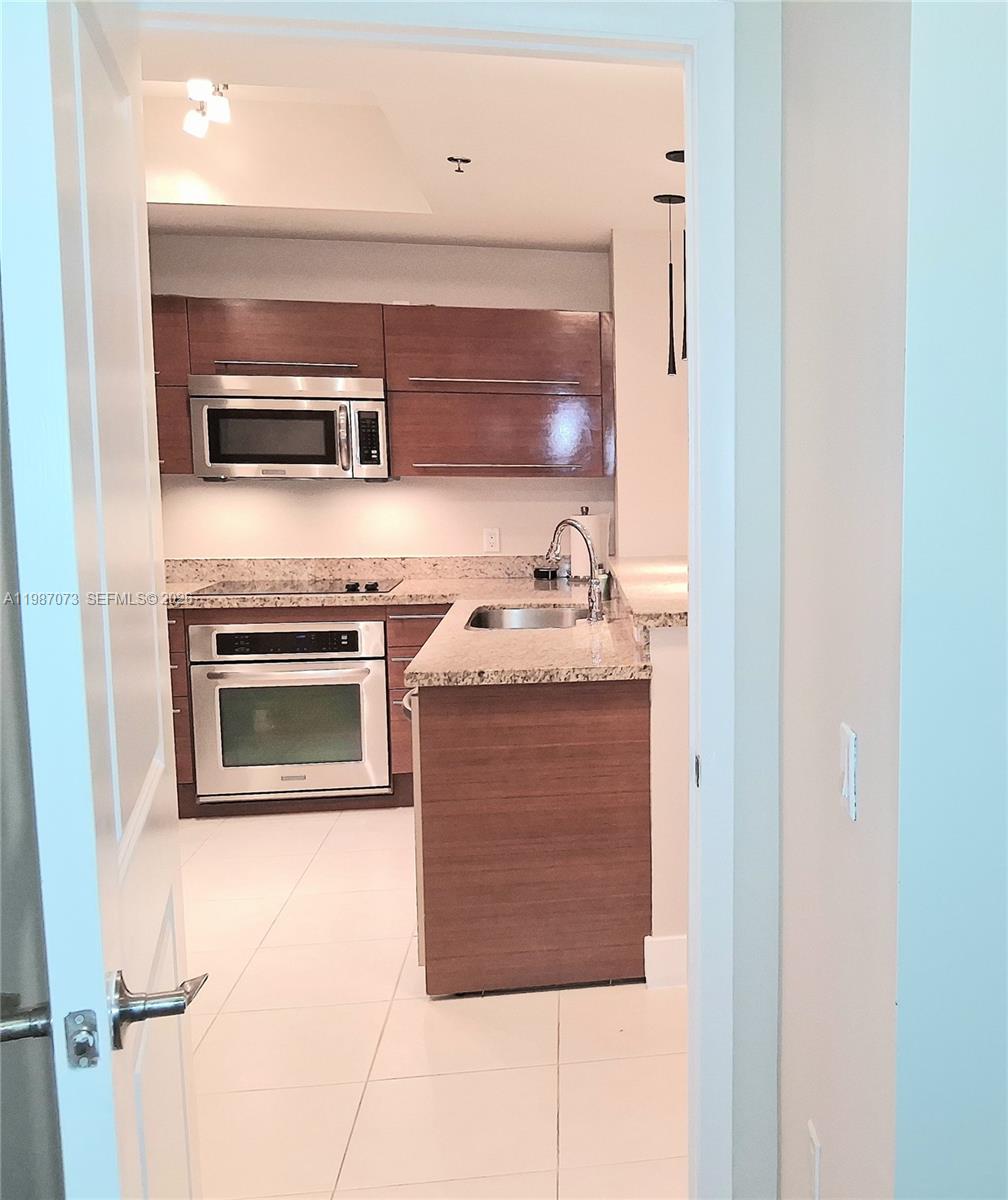 2641 North Flamingo Road, Unit 2607N Sunrise, FL 33323 - Photo 25 of 69 a kitchen with a stove and a microwave