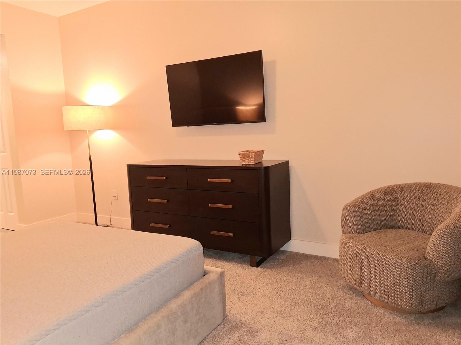 2641 North Flamingo Road, Unit 2607N Sunrise, FL 33323 - Photo 30 of 69 a bedroom with a bed and a flat screen tv