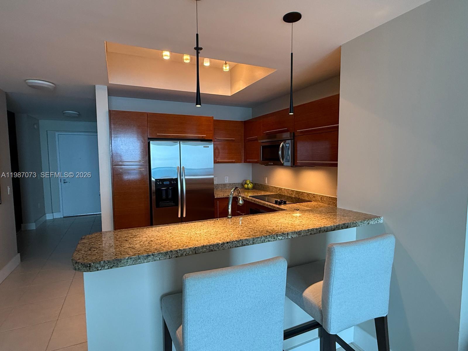 2641 North Flamingo Road, Unit 2607N Sunrise, FL 33323 - Photo 9 of 69 a kitchen with a sink a counter and chairs