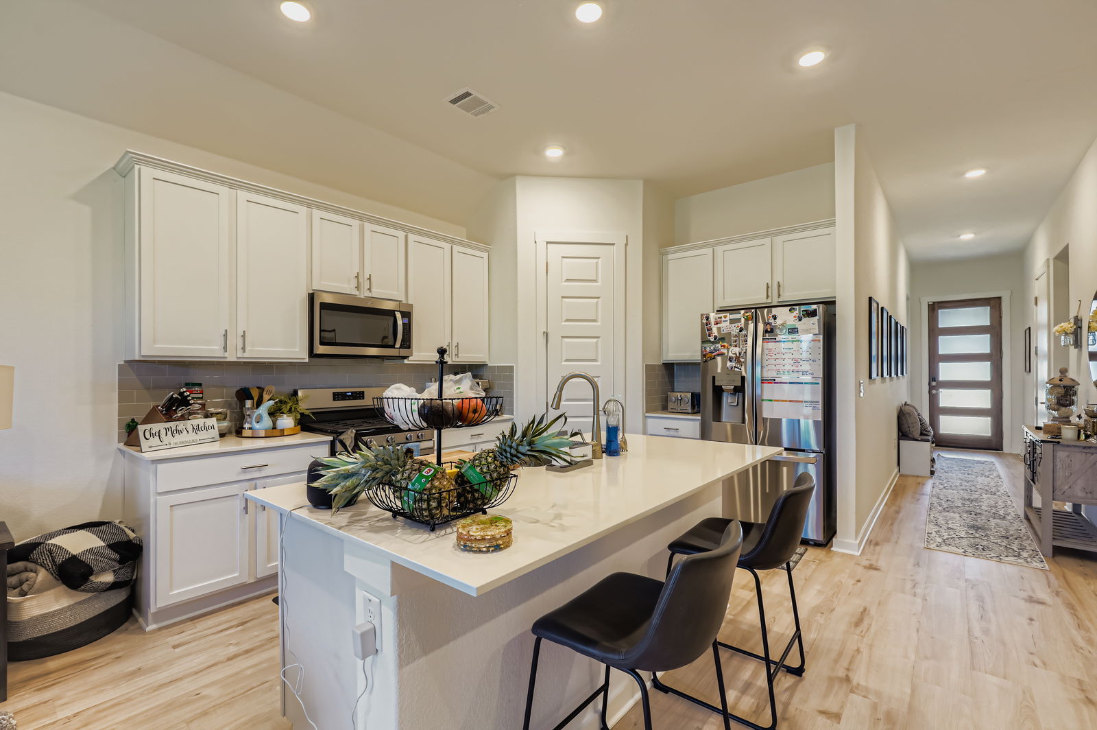 1909 Ruger Pass Leander, TX 78641 - Photo 7 of 31 Kitchen featuring recessed lighting, backsplash, appliances with stainless steel finishes, a breakfast bar, and white cabinetry