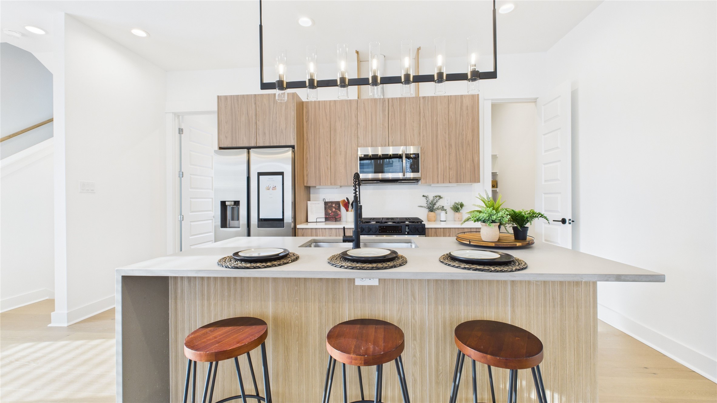 2428 Freeman Street Houston, TX 77009 - Photo 15 of 46 The heart of the second-floor open-concept living, dining, and kitchen, this spacious kitchen island features sleek modern finishes, including a one-sided cascade quartz countertop, a farmhouse sink, and stylish pendant lighting, with a built-in seating area perfect for casual breakfasts or chatting with family and friends.