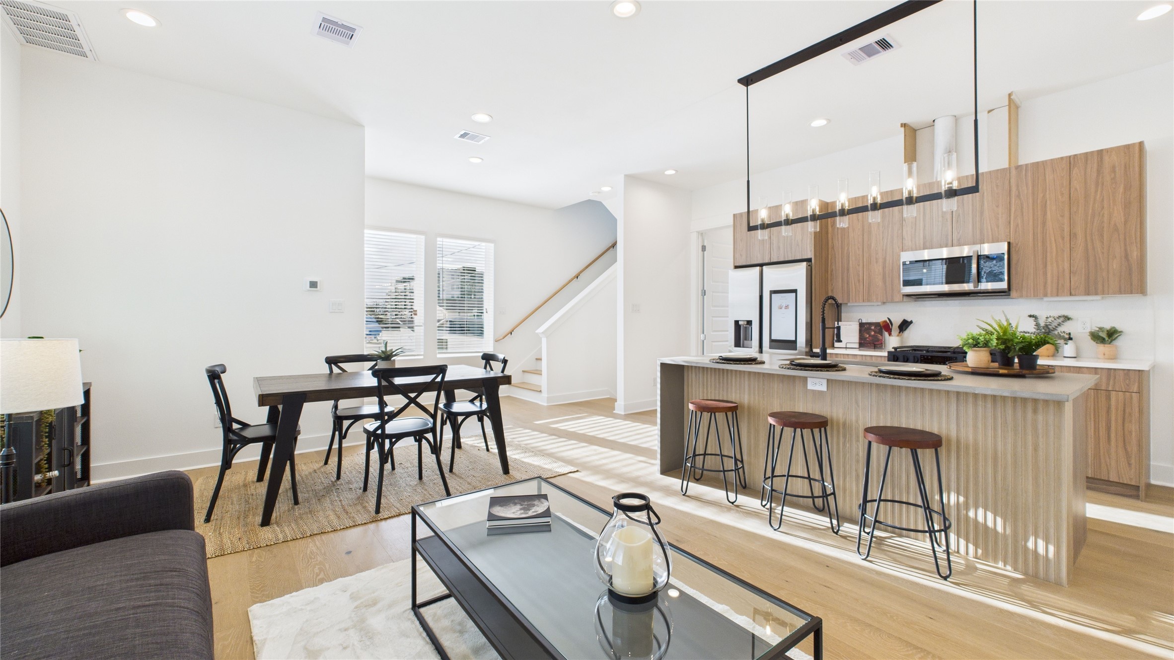 2428 Freeman Street Houston, TX 77009 - Photo 4 of 46 The welcoming second-floor open-concept living area seamlessly combines the living room, dining room, and kitchen, filled with natural light and enhanced by modern finishes and engineered hardwood flooring throughout, creating a bright and inviting space ideal for everyday living and entertaining.