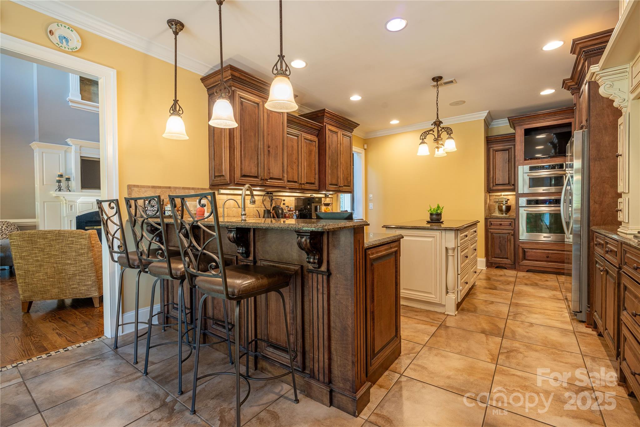 1427 Merrimont Avenue Kings Mountain, NC 28086 - Photo 17 of 48 a kitchen with kitchen island granite countertop a table chairs sink and cabinets