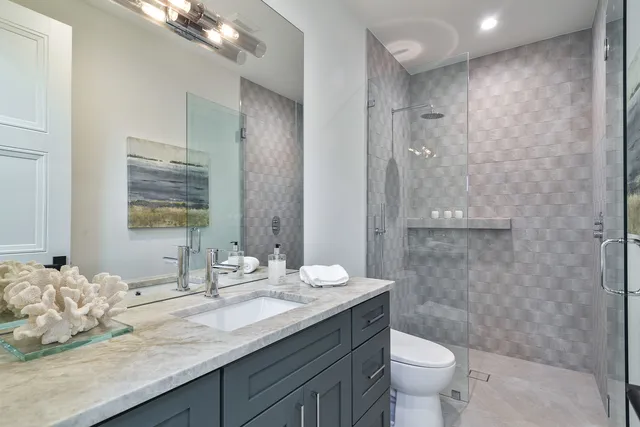 a bathroom with a sink a toilet and shower