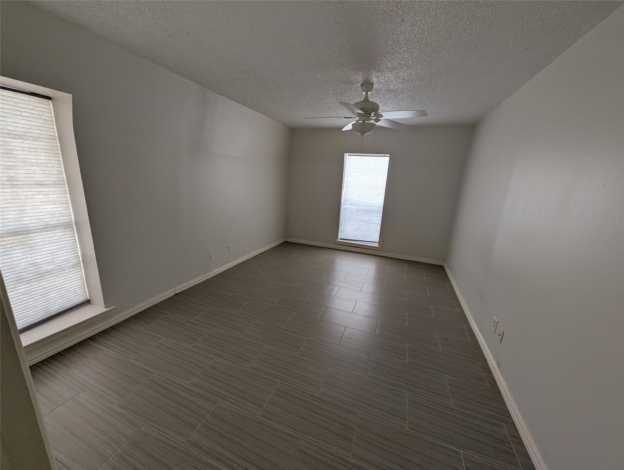 9017 Rue Cambon Street, Unit 98 Houston, TX 77074 - Photo 10 of 11 an empty room with wooden floor and windows