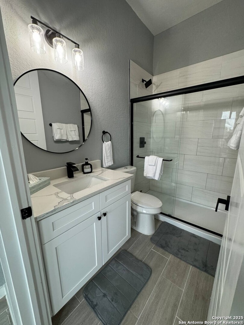 1652 Rimrock Cove Spring Branch, TX 78070 - Photo 15 of 26 a bathroom with a toilet a sink and a mirror