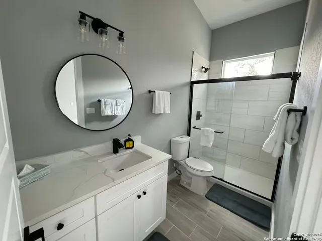 a bathroom with a toilet a sink and a mirror