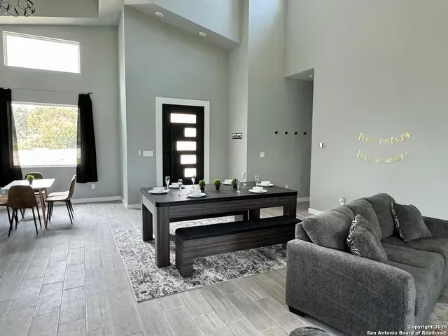 a living room with furniture and a large mirror next to a window