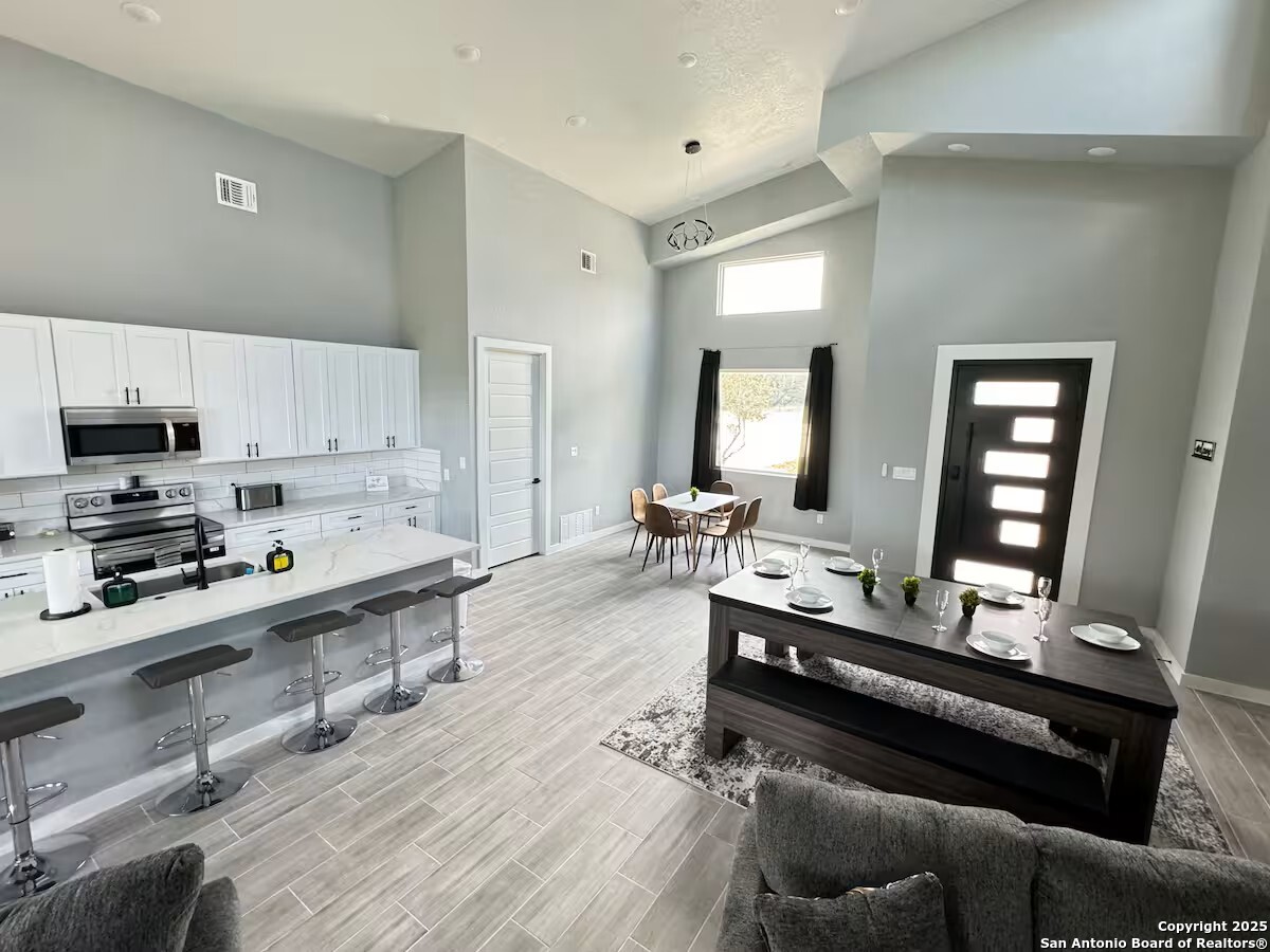 1652 Rimrock Cove Spring Branch, TX 78070 - Photo 5 of 26 a large kitchen with stainless steel appliances a stove a sink dishwasher and cabinets with wooden floor