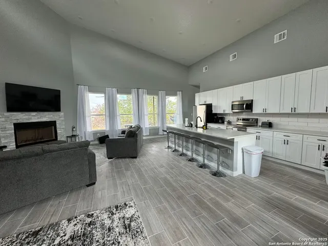 a kitchen with furniture a flat screen tv and a fireplace