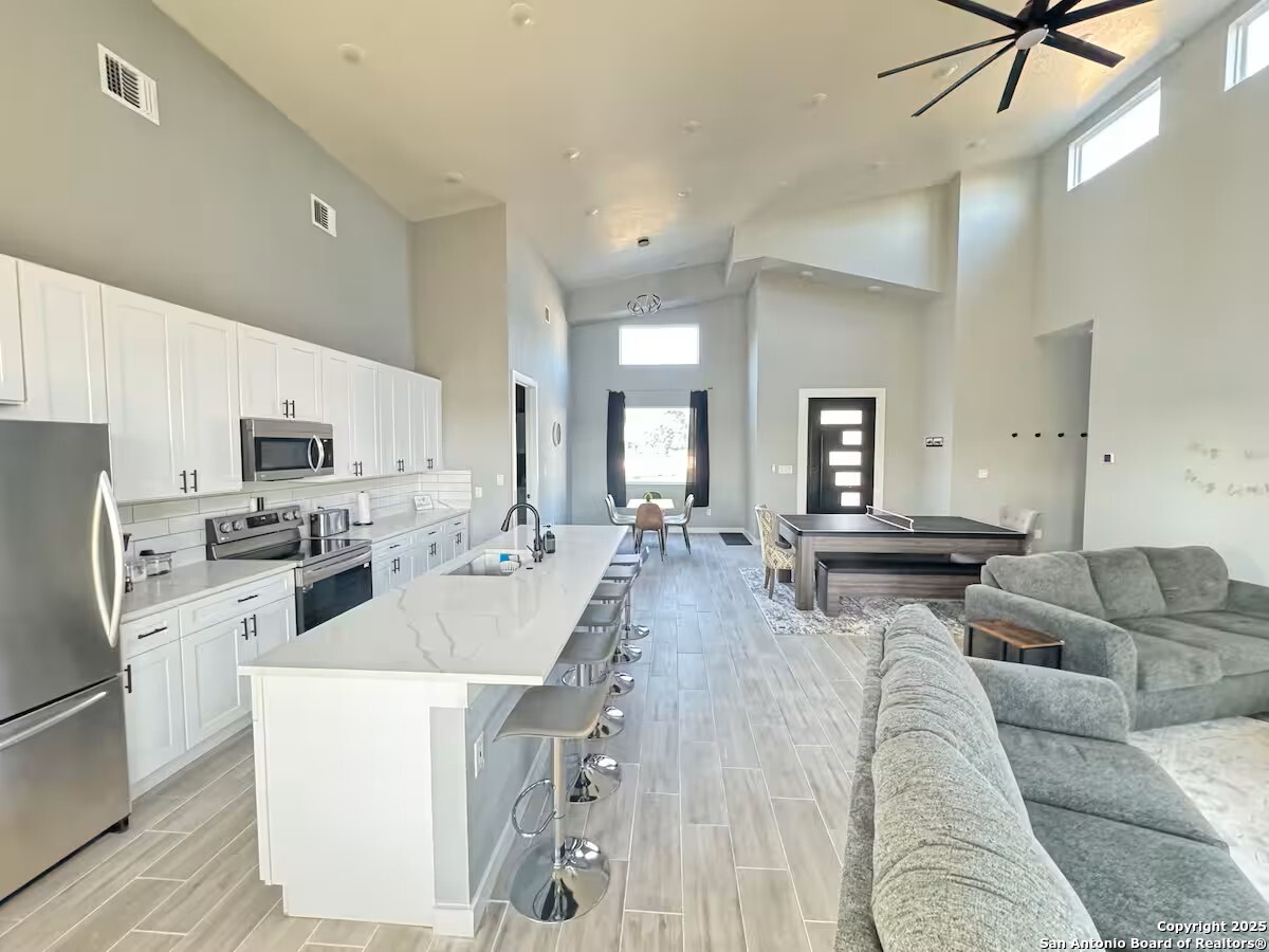 1652 Rimrock Cove Spring Branch, TX 78070 - Photo 9 of 26 a living room with stainless steel appliances kitchen island furniture and a view of kitchen