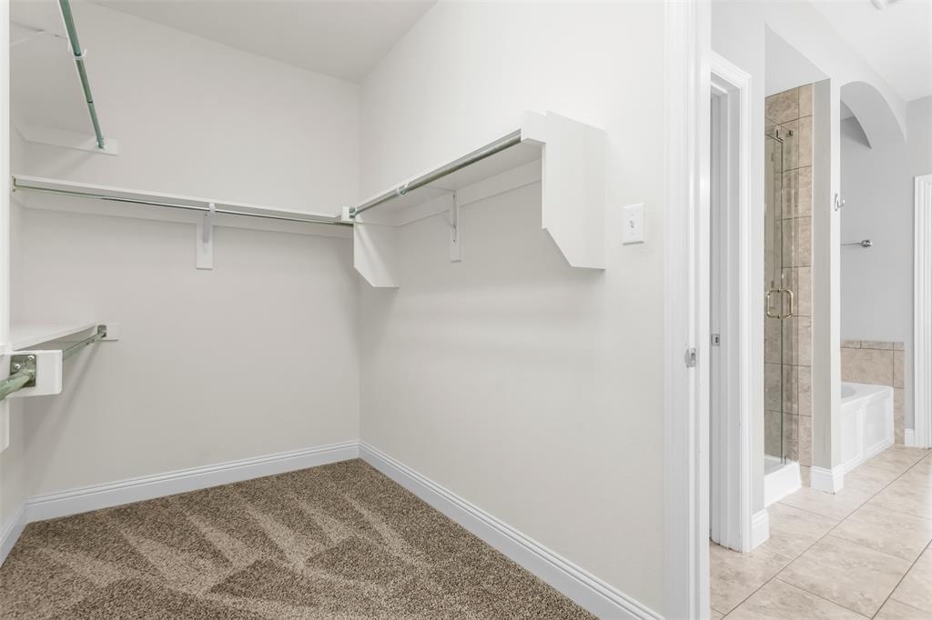 15713 Canyon Ridge Prosper, TX 75078 - Photo 25 of 38 Walk-in closet featuring built-in shelving, hanging rods, and carpet flooring