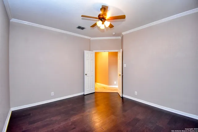 a view of an empty room with a window and wooden floor