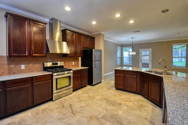 a kitchen with stainless steel appliances granite countertop wooden cabinets a stove top oven a sink and dishwasher