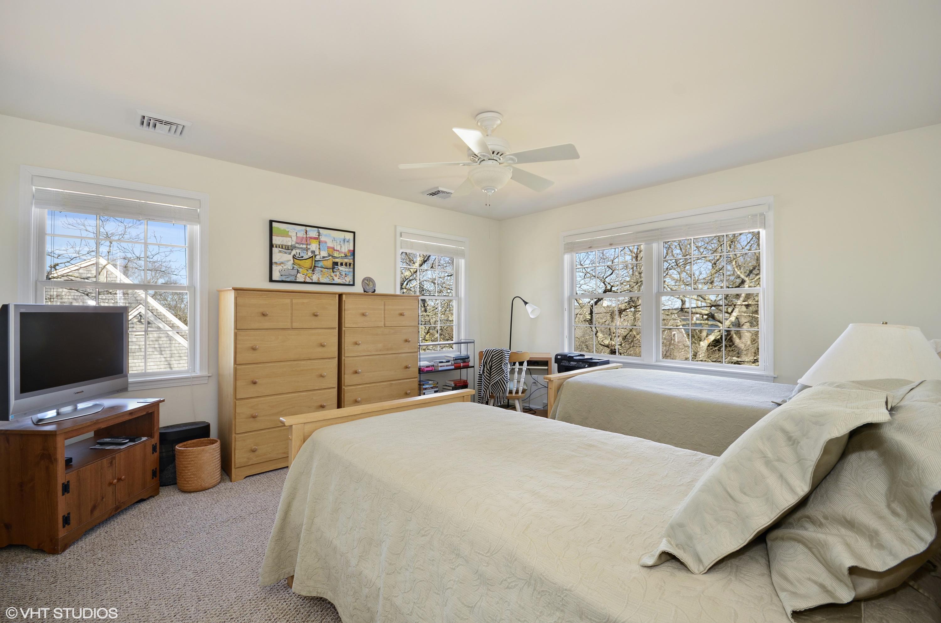 99 Mashnee Road Bourne, MA 02532 - Photo 14 of 25 a spacious bedroom with a bed and a flat screen tv