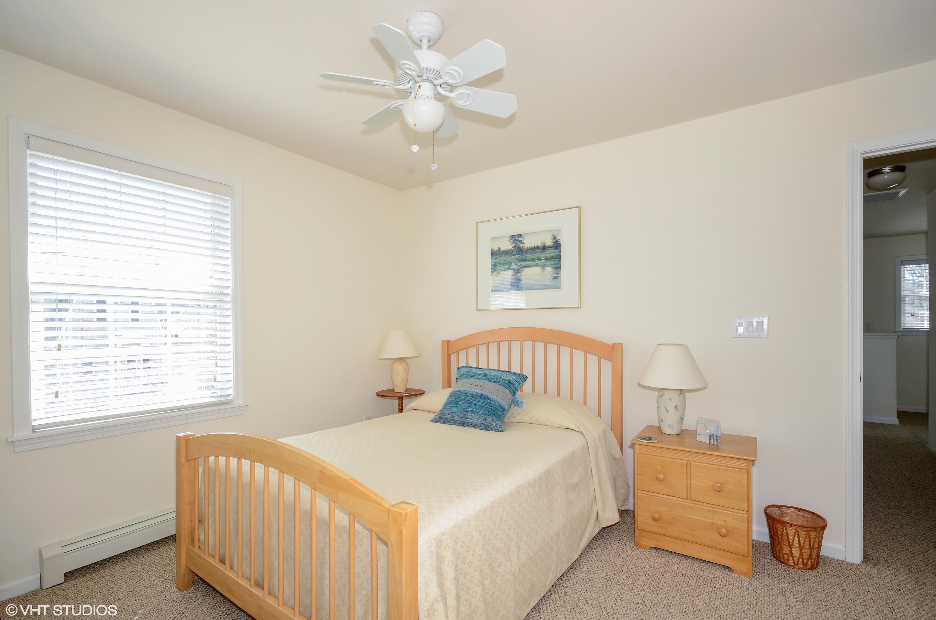 99 Mashnee Road Bourne, MA 02532 - Photo 17 of 25 a bedroom with a bed and a chandelier