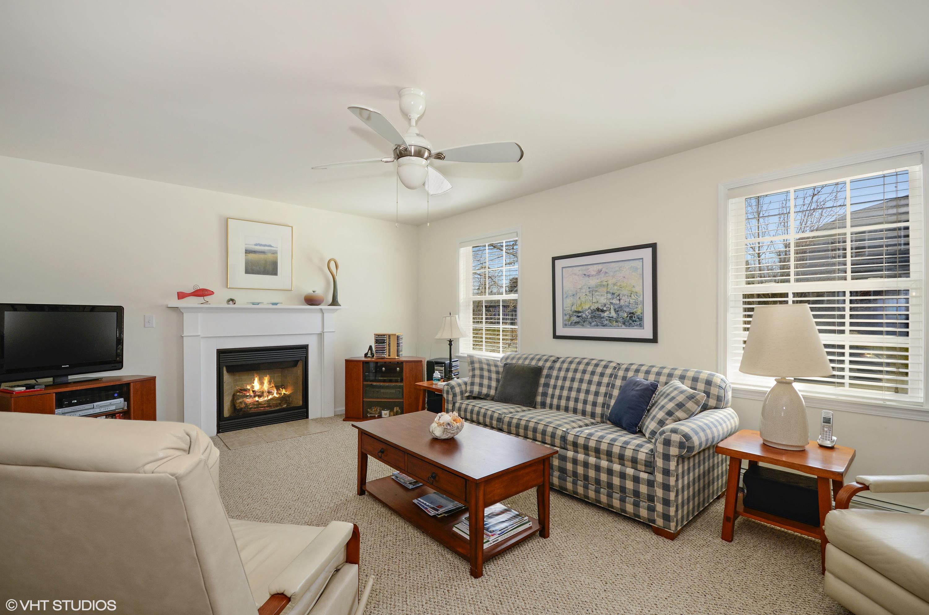 99 Mashnee Road Bourne, MA 02532 - Photo 6 of 25 a living room with furniture a flat screen tv and a fireplace