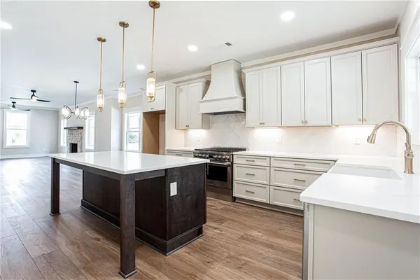 a kitchen with stainless steel appliances granite countertop a sink a stove and a refrigerator