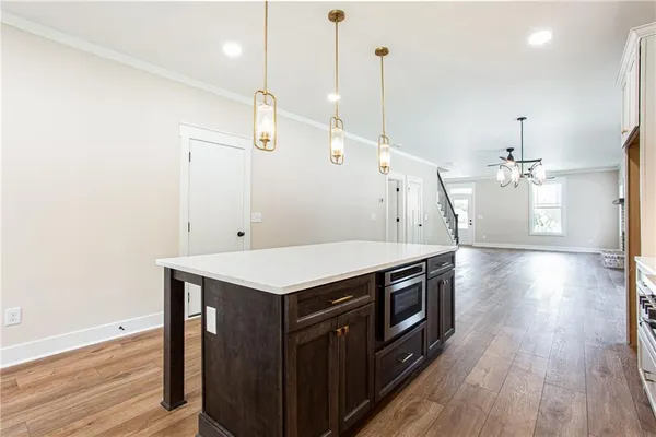 a kitchen that has a lot of cabinets and wooden floor